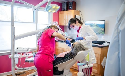biological dentist in atlanta with patient and associate biological dentist atlanta with associate performing procedure on patient in office