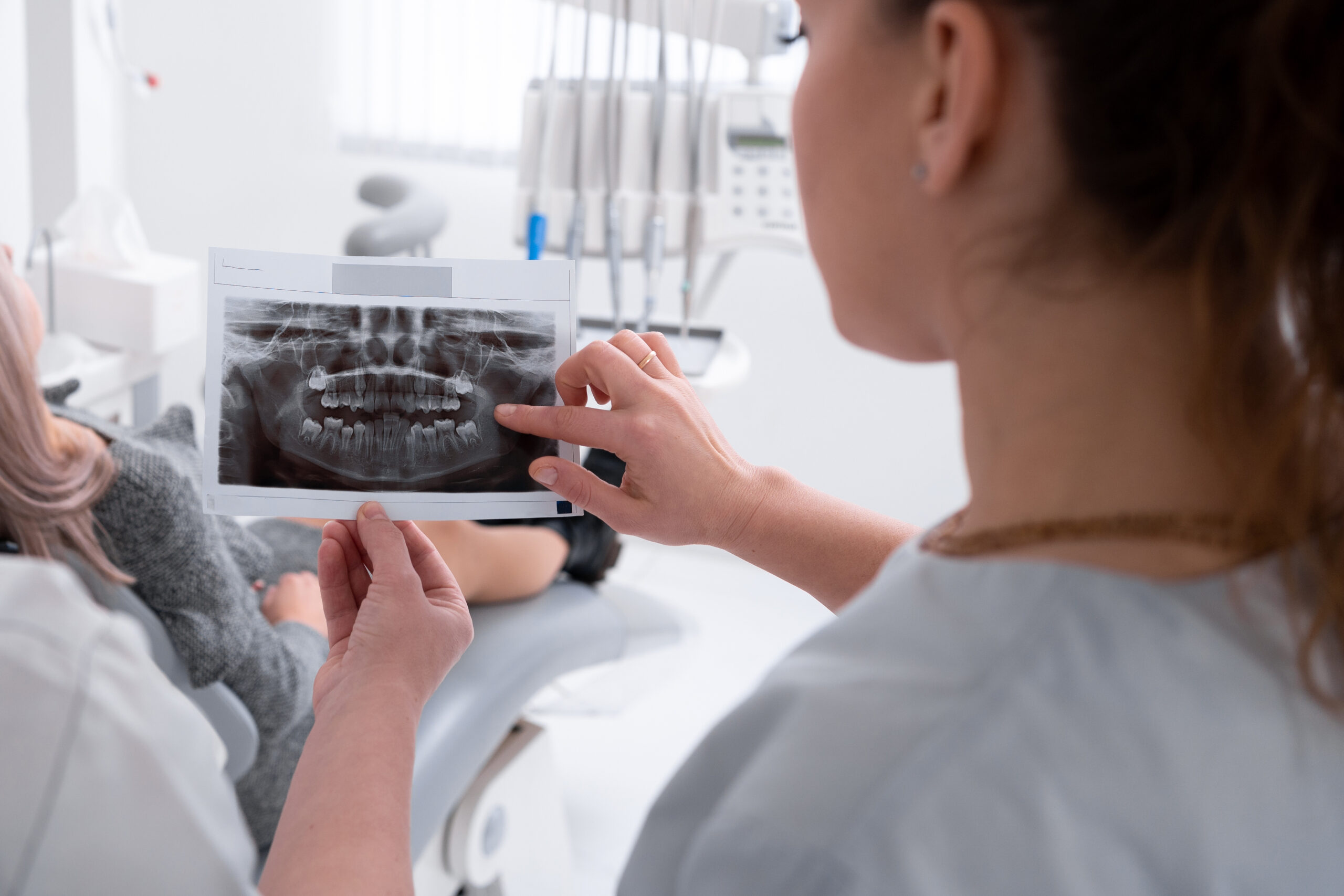 Dentist Reviewing Dental X-Ray – Rose Dental Female dentist reviewing dental X-ray of patient teeth at Rose Dental in Tucker, GA