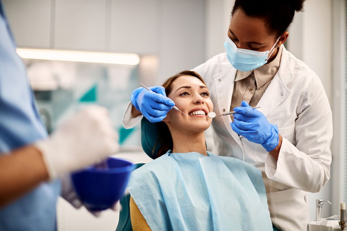 AdobeStock_473940984 Young smiling woman having a dental exam at Rose Dental