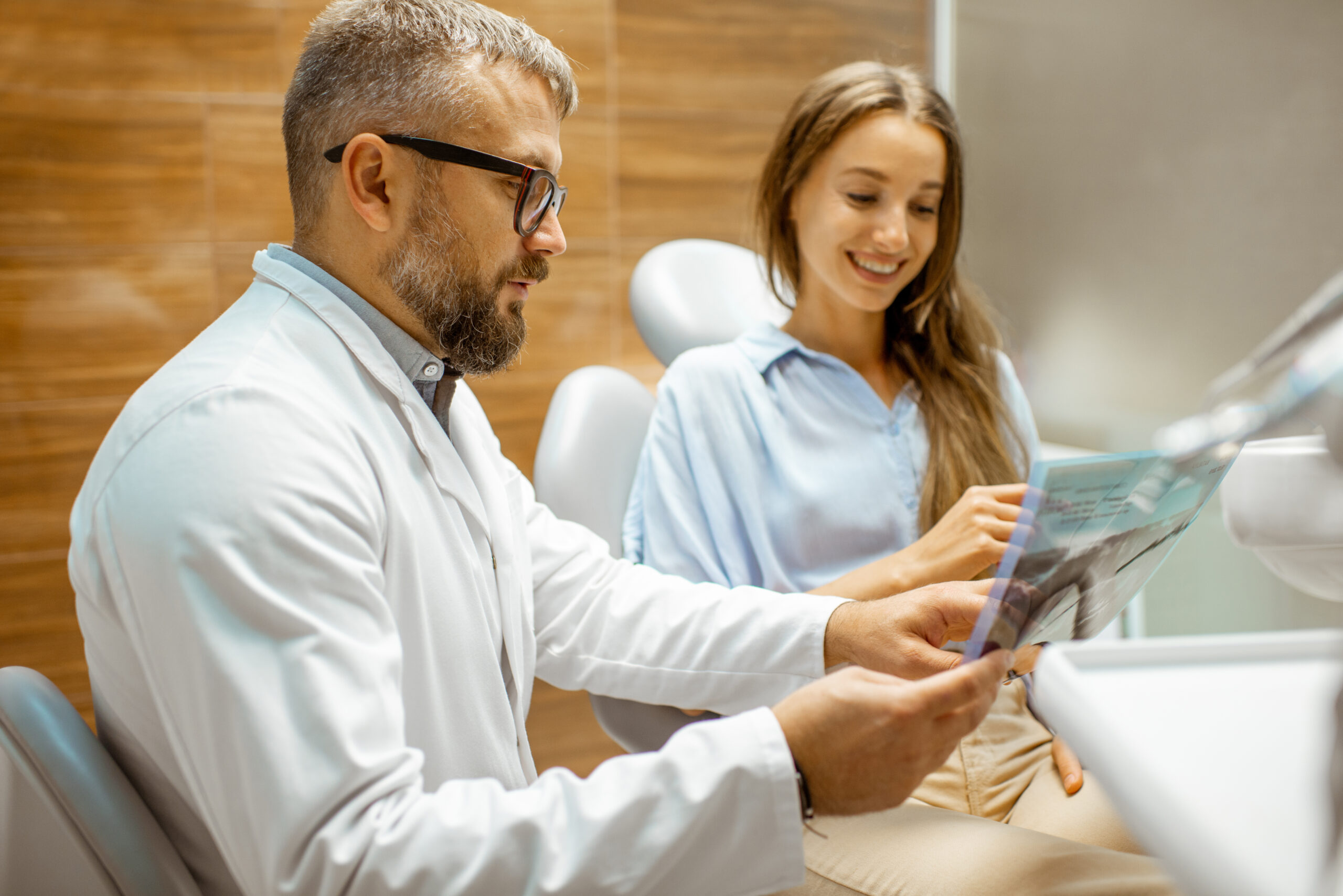 Dentist patient consultation with x-ray Dentist discussing gum health and whole-body wellness with a patient