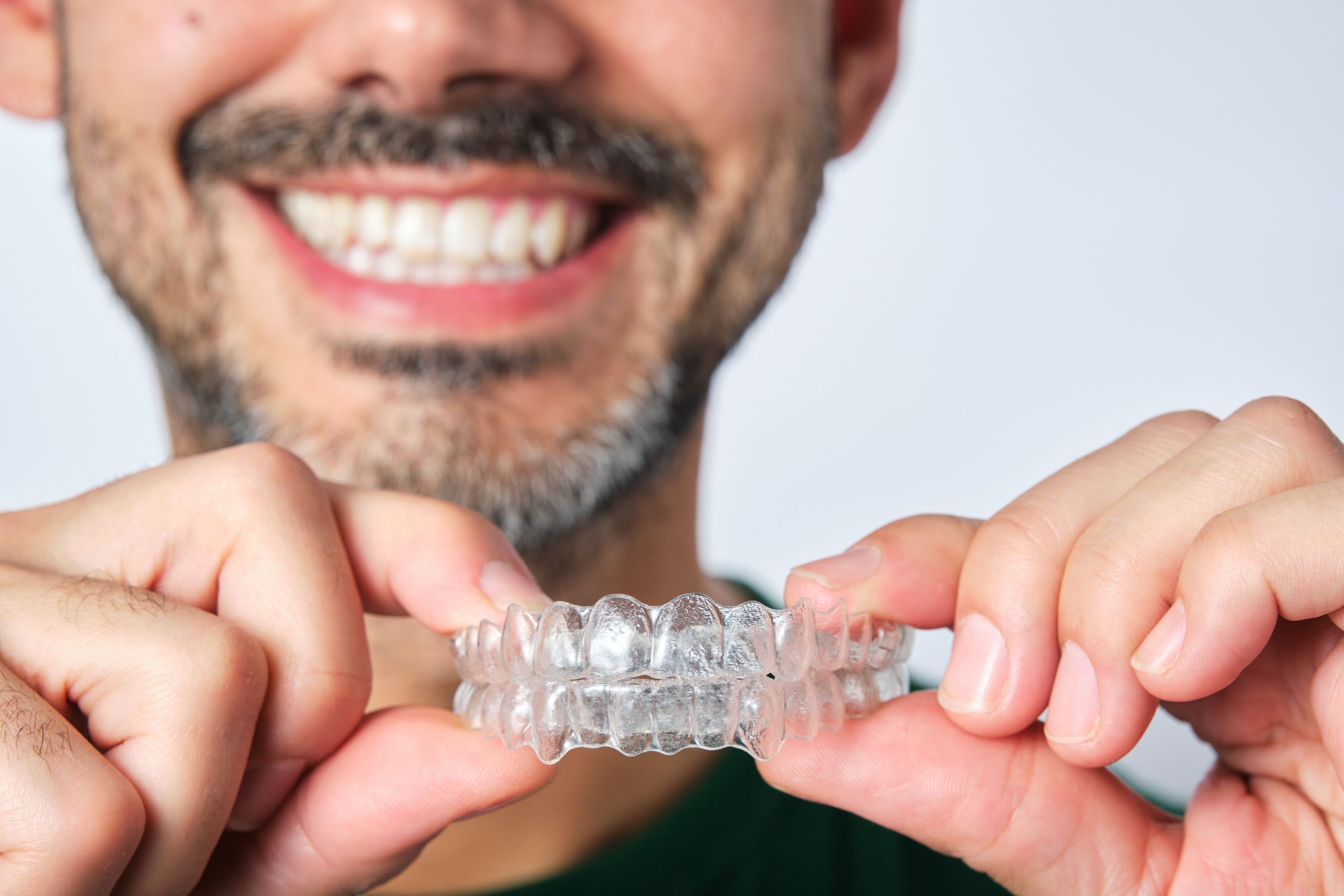 Man with a transparent dental retainer, illustrating clear aligners as an option for straightening teeth