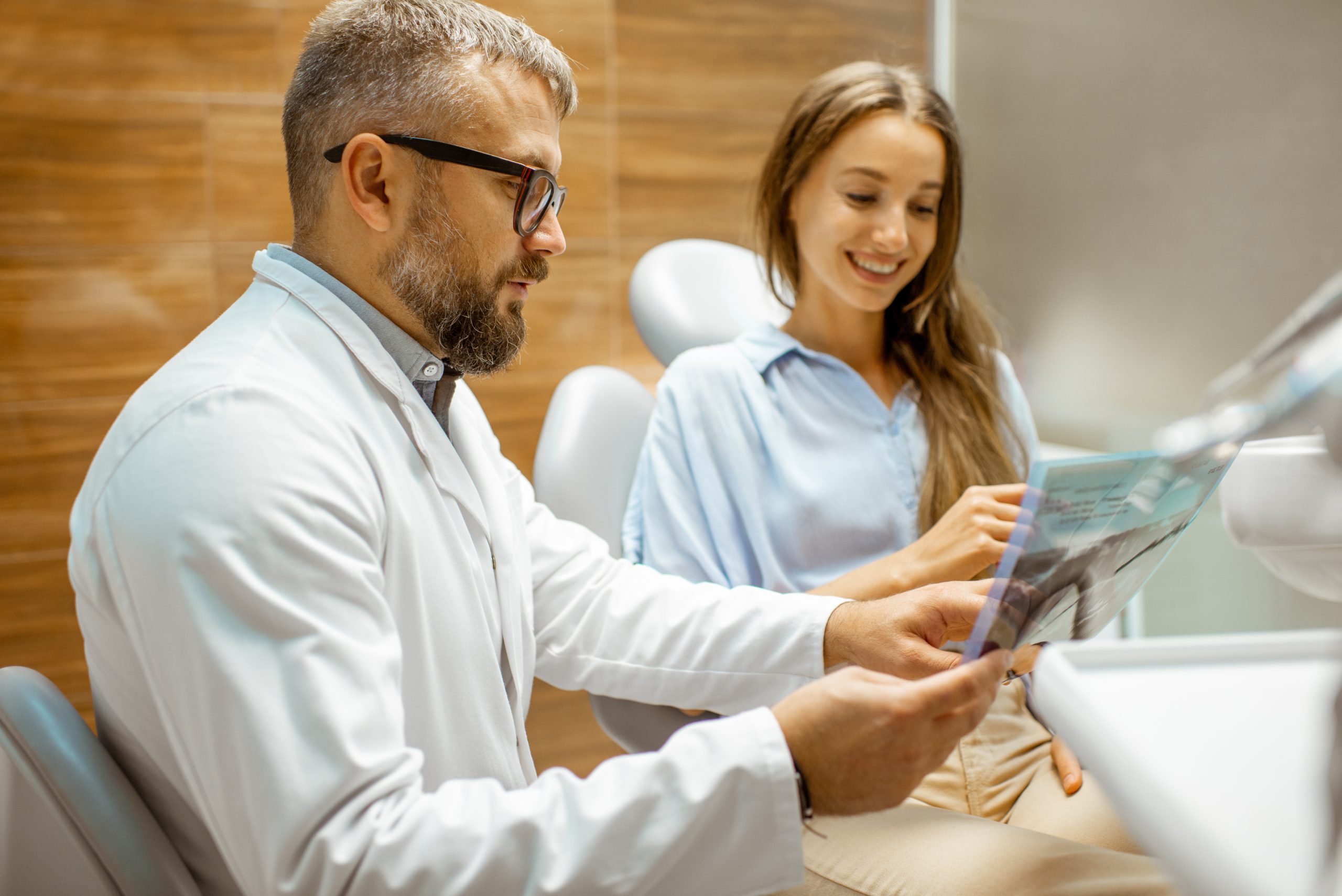Second Opinion Dental Consultation at Rose Dental Dentist reviewing dental X-rays with a patient during a second opinion consultation at Rose Dental